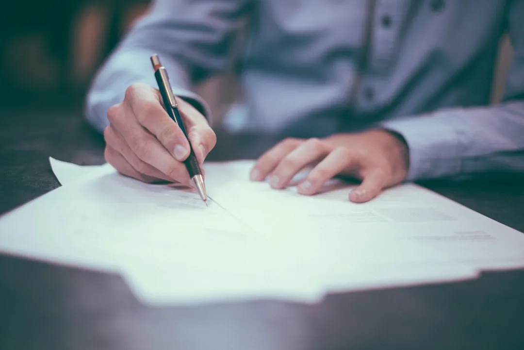 Business professional reviewing lease and contract documents at desk