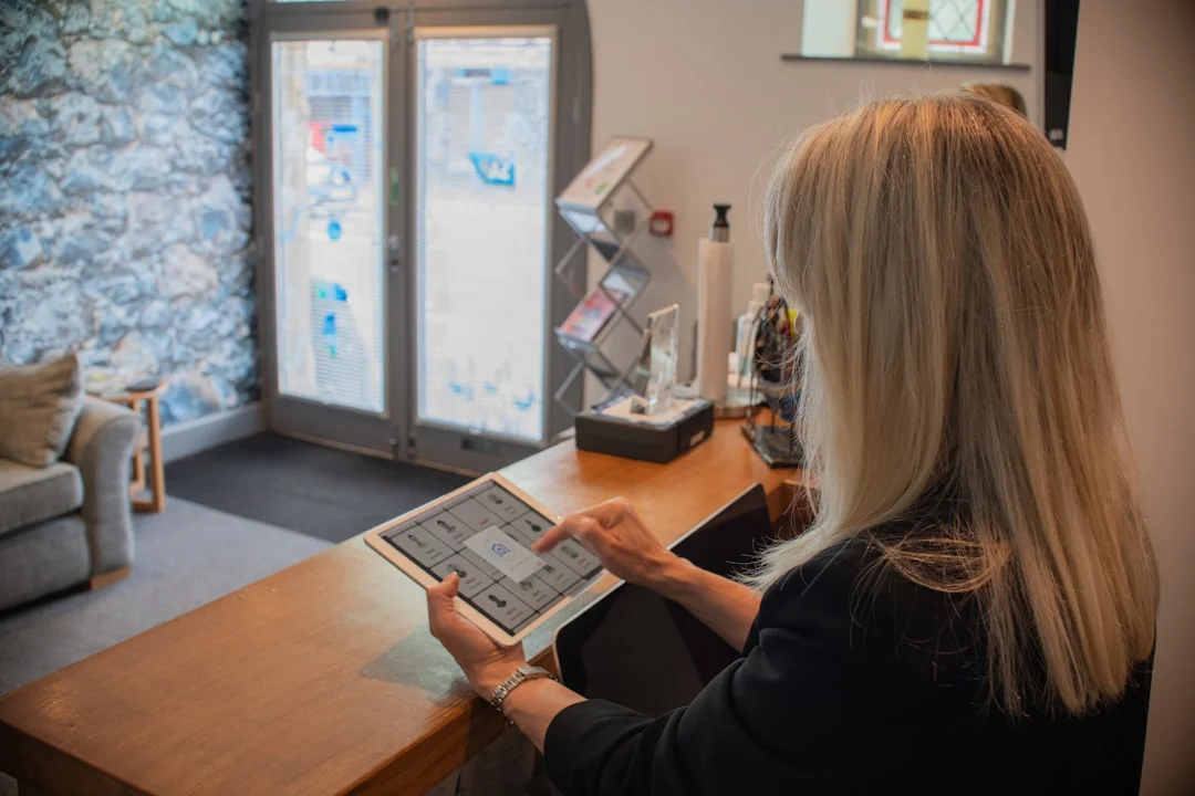 Franchise owner reviewing multiple location performance reports on tablet in modern office