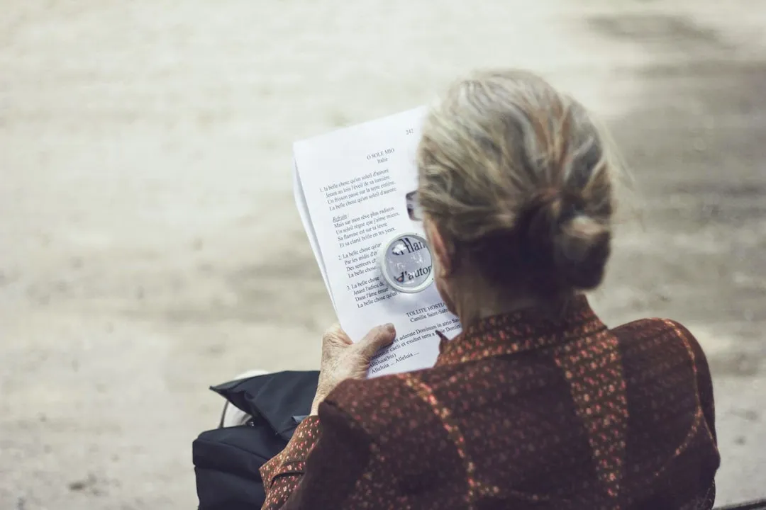 Person reviewing contract fine print with magnifying glass